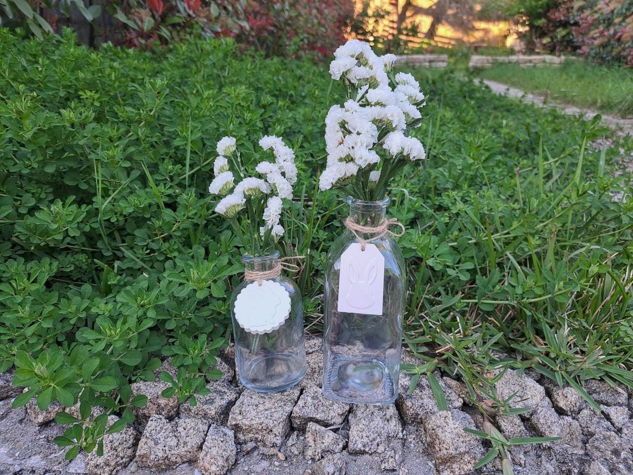 Duas garrafas decorativas em vidro com flores